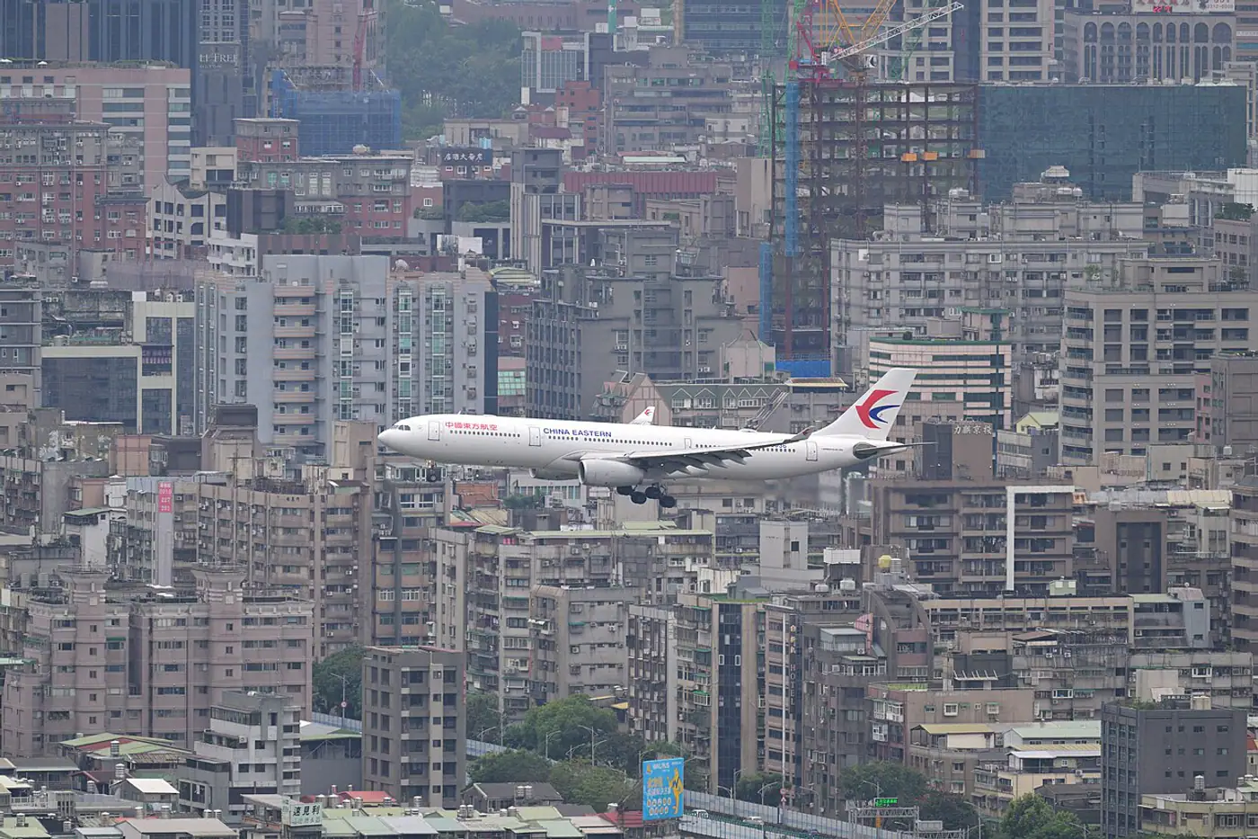 Avião da China Eastern em aproximação sobre uma área urbana