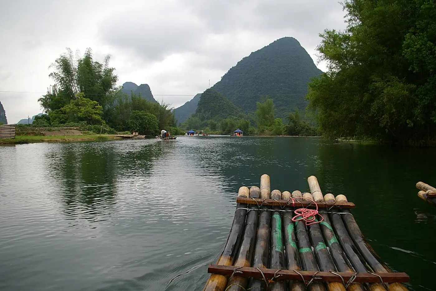 Jangada de bambu no Rio Yulong cercada por montanhas verdes em Yangshuo