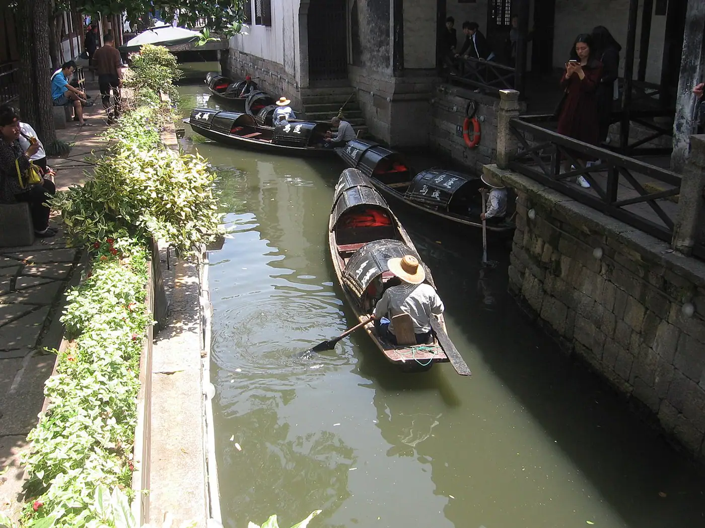 Barcos de toldo preto navegando por um canal estreito de Shaoxing